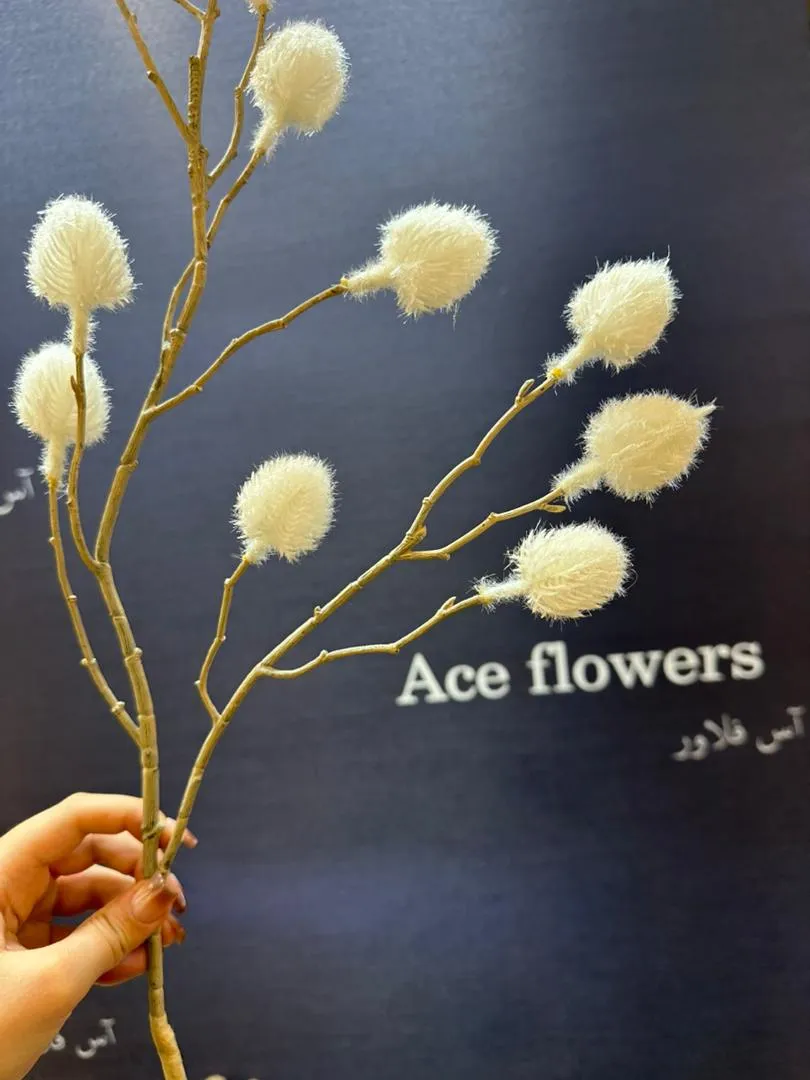 دکوراسیون مینیمال زمستانی با شاخه پشمکی سفید روی میز کنار مبل